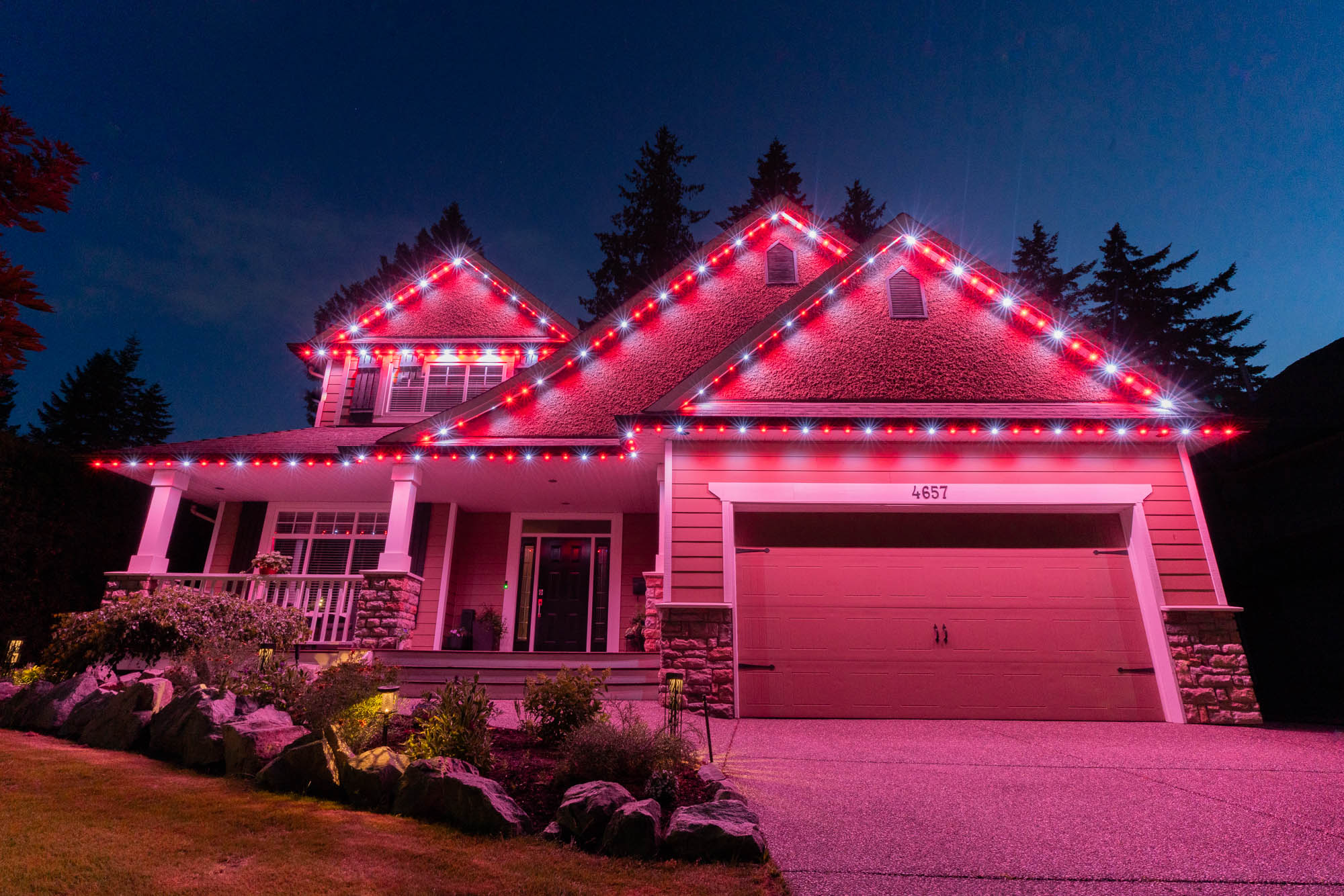 Blue Christmas roofline lights on a home at night