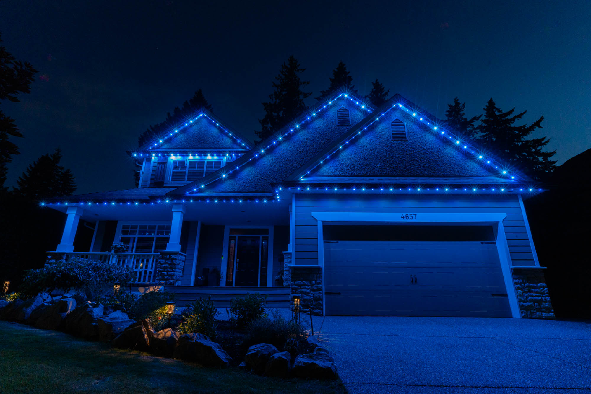 Christmas lighting scenes on a home exterior at night